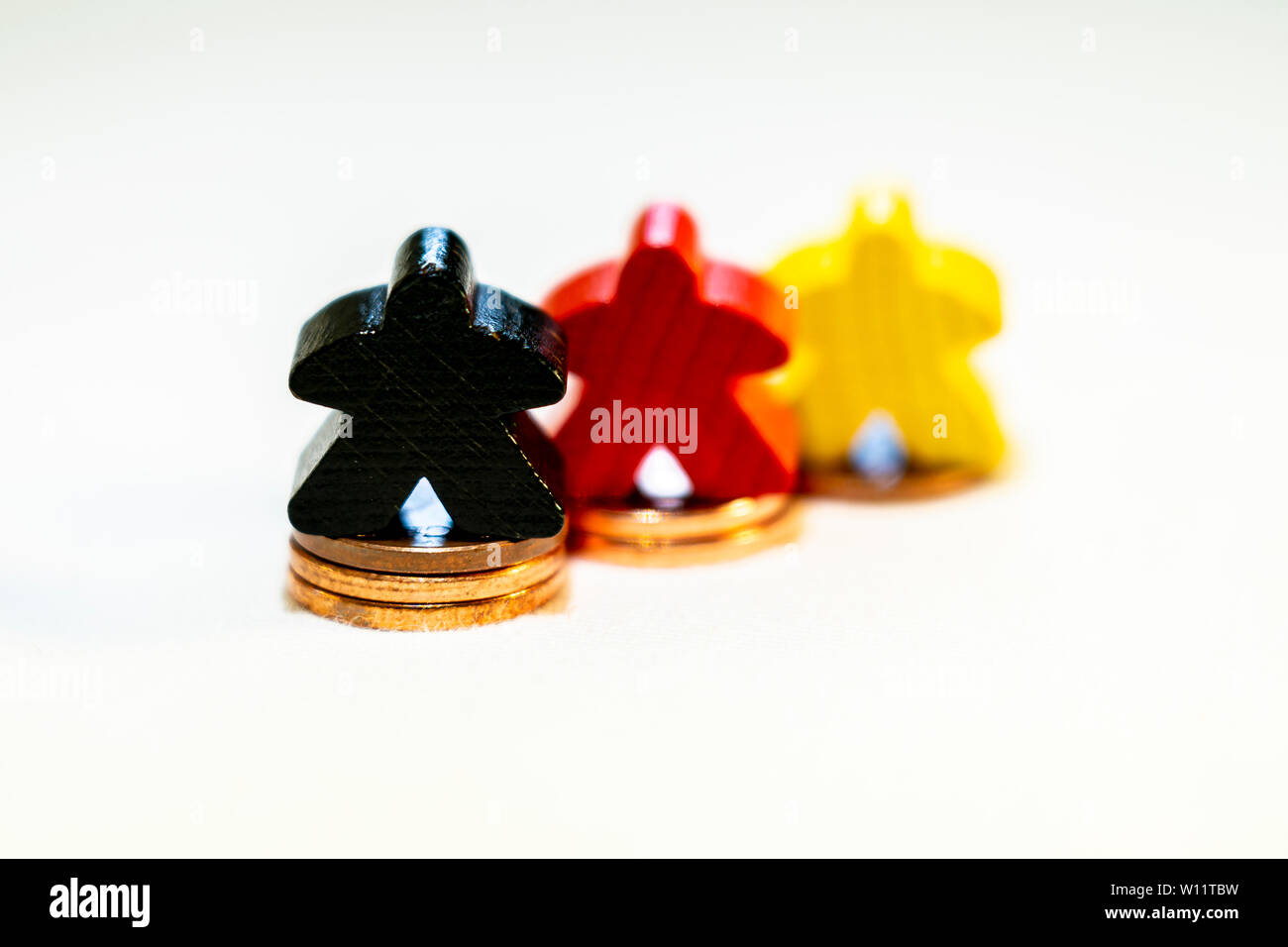 Illustrazione di successo finanziario con gioco in legno figure e delle monete metalliche in euro Foto Stock