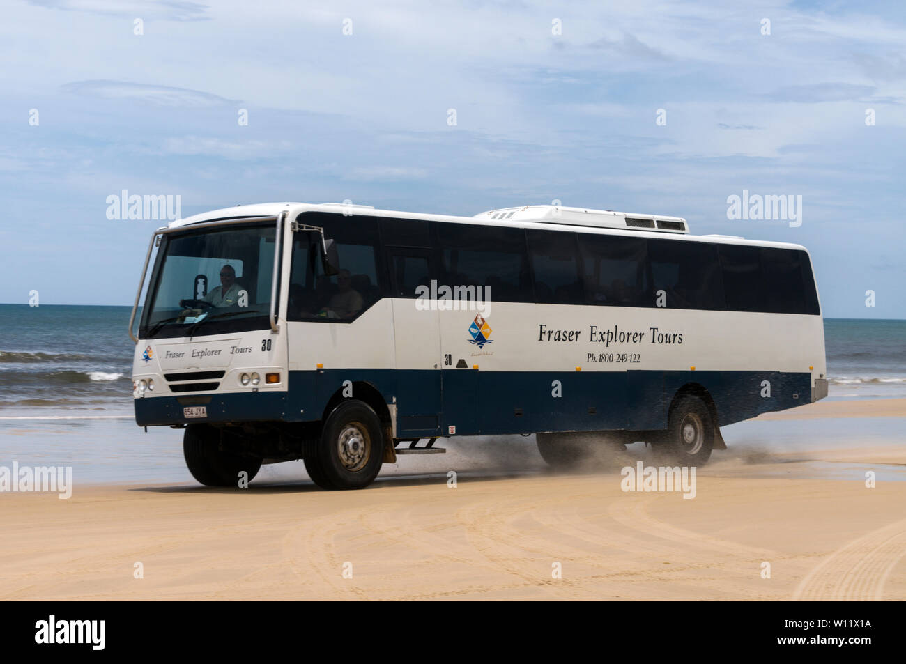 Un autobus turistico guida su vasta spiaggia sabbiosa di 75 miglia di sabbia lunga autostrada su Fraser Island, Queensland, Australia Fraser Island è un mondo egli Foto Stock