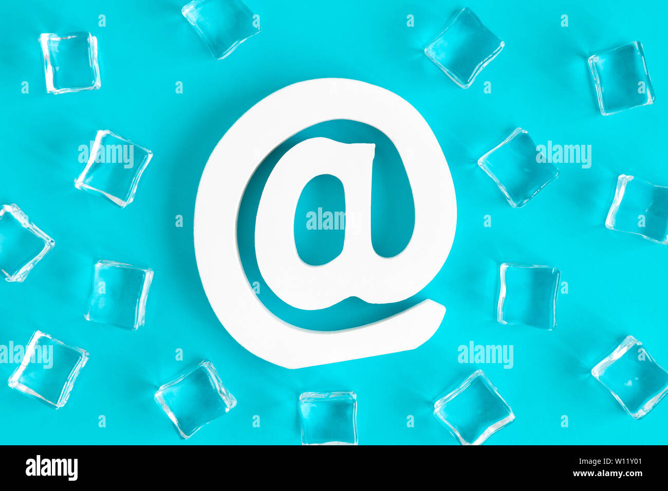 Piatto di laici e-mail firmare e cubetti di ghiaccio contro sfondo blu il minimo concetto creativo. Foto Stock