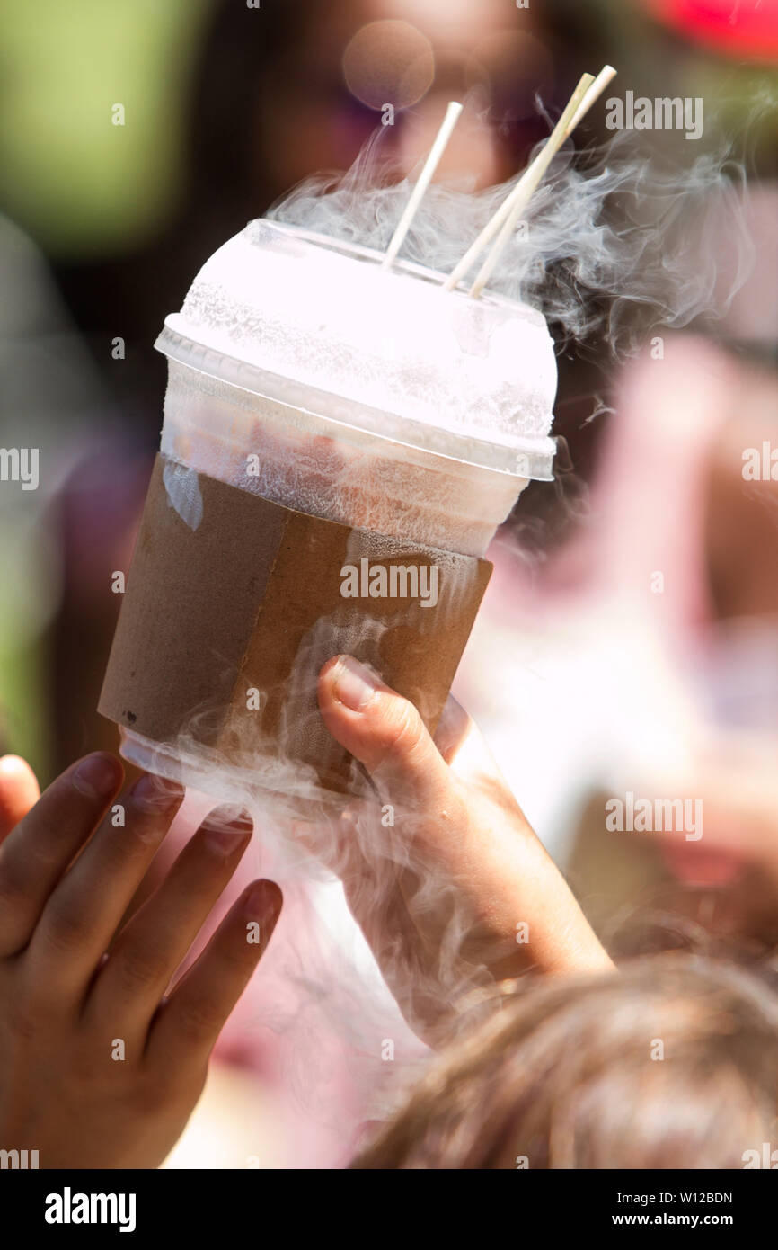 Un bambino mano trattiene un estremamente freddo trattare fatta con azoto liquido a un gelato festival. Foto Stock