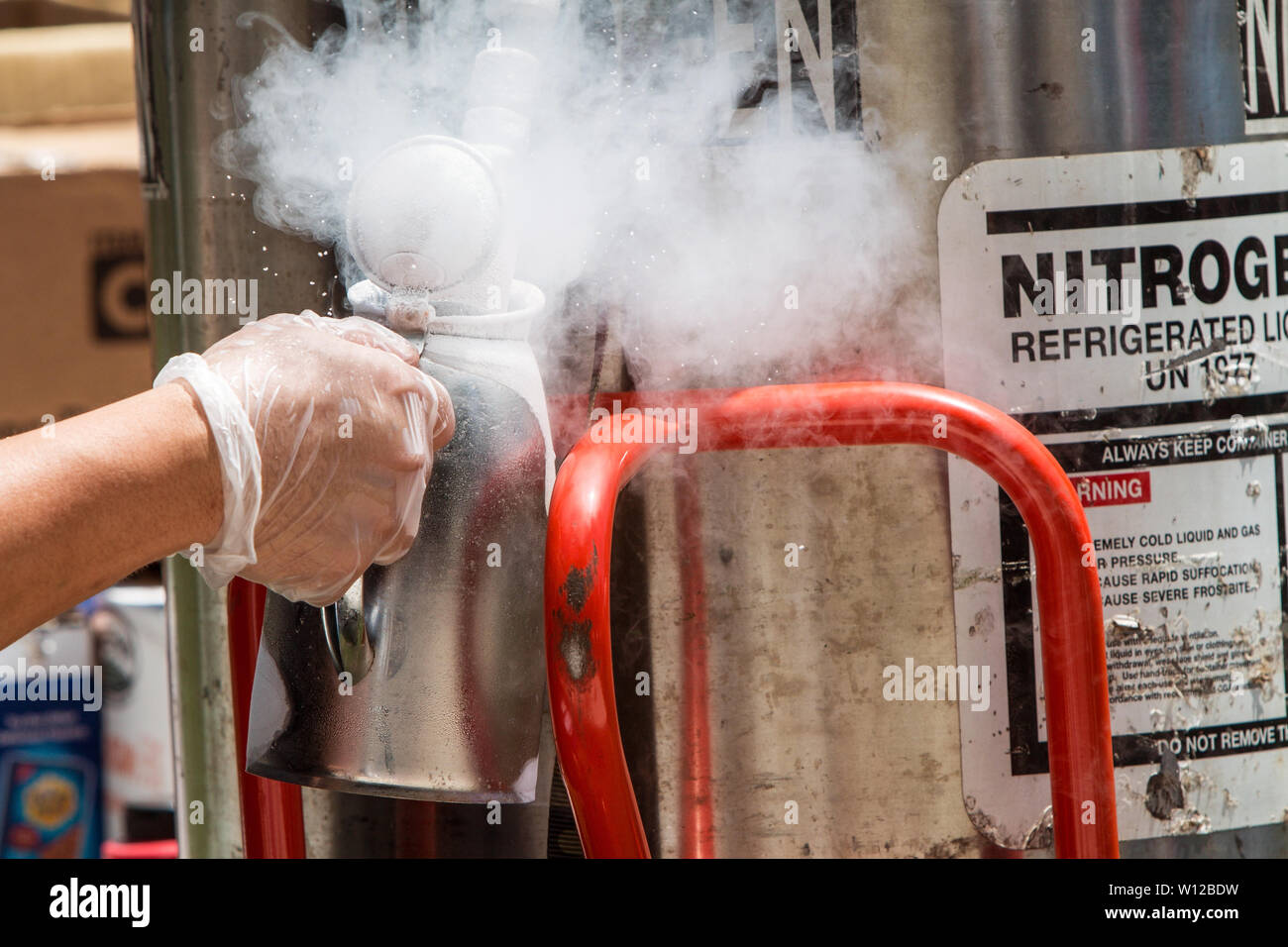 Un uomo si riempie di un acciaio inossidabile brocca con azoto liquido per rendere deserti congelati ad Atlanta Gelato Festival il 28 luglio 2018 ad Atlanta, GA. Foto Stock