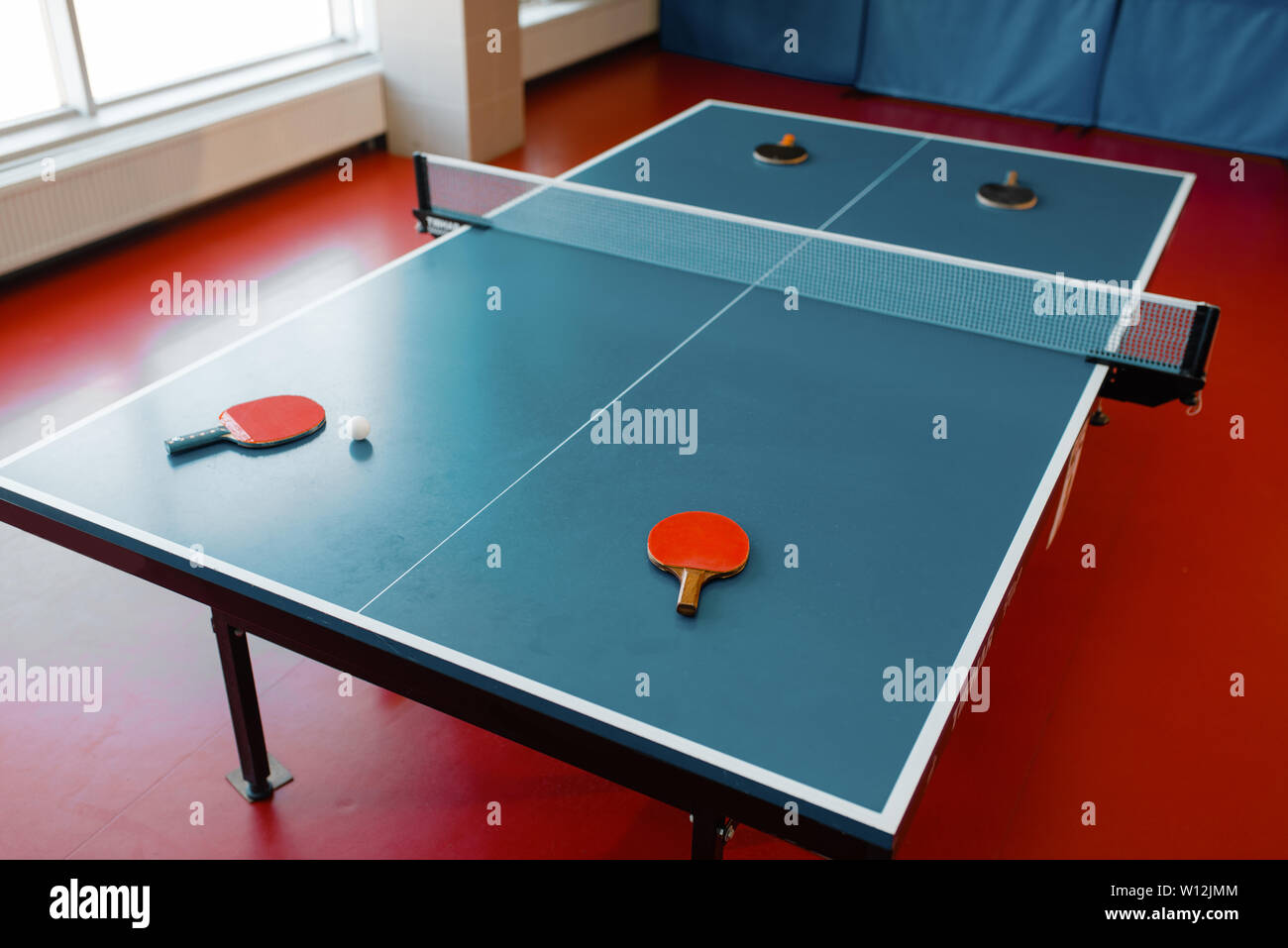 Ping pong racchette sul tavolo da gioco con net, nessuno Foto Stock