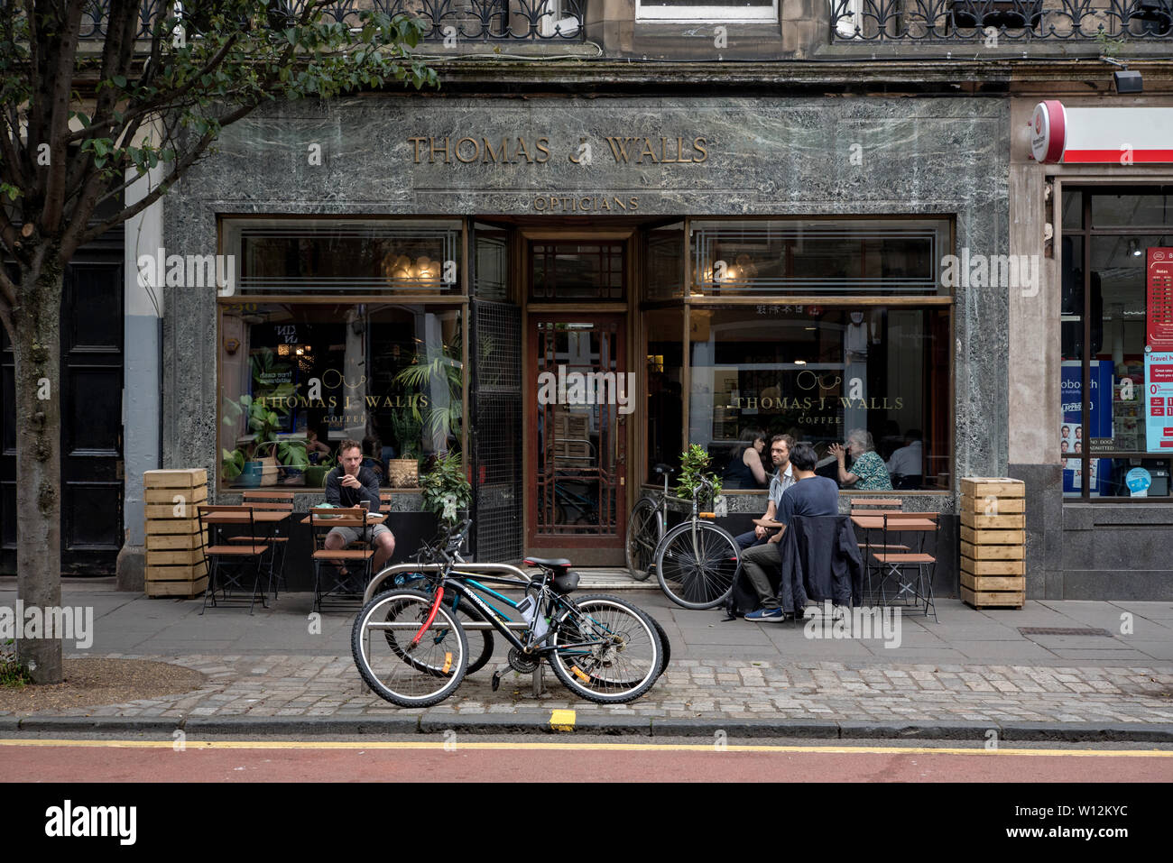 Il digital signage di Thomas J pareti ottici è stato trattenuto quando i locali sono stati convertiti in un cafe'. Forrest Road, Edimburgo, Scozia, Regno Unito. Foto Stock