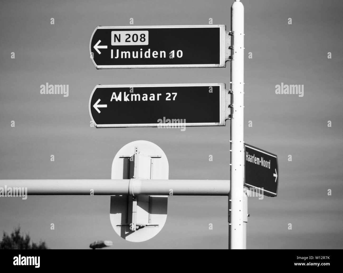 Futch via autostrada segno con le direzioni di IJmuiden, Alkmaar,- cielo chiaro nello sfondo - bianco e nero Foto Stock