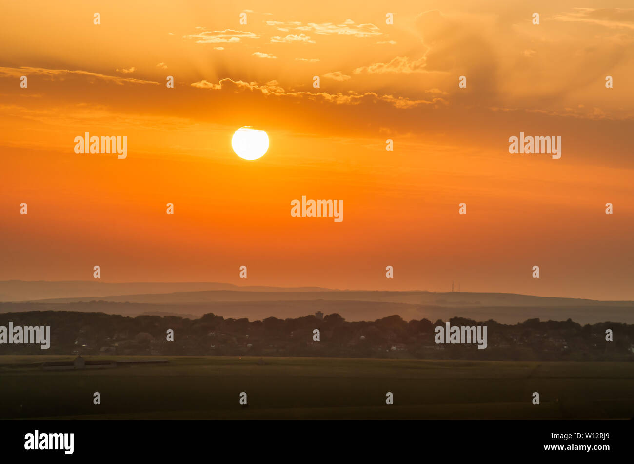 Beachy Head, Eastbourne, East Sussex, Regno Unito..26th Giugno 2019..Sun si affaccia sulla campagna mentre la nebbia marina si muove nell'addolcire la scena. . Foto Stock