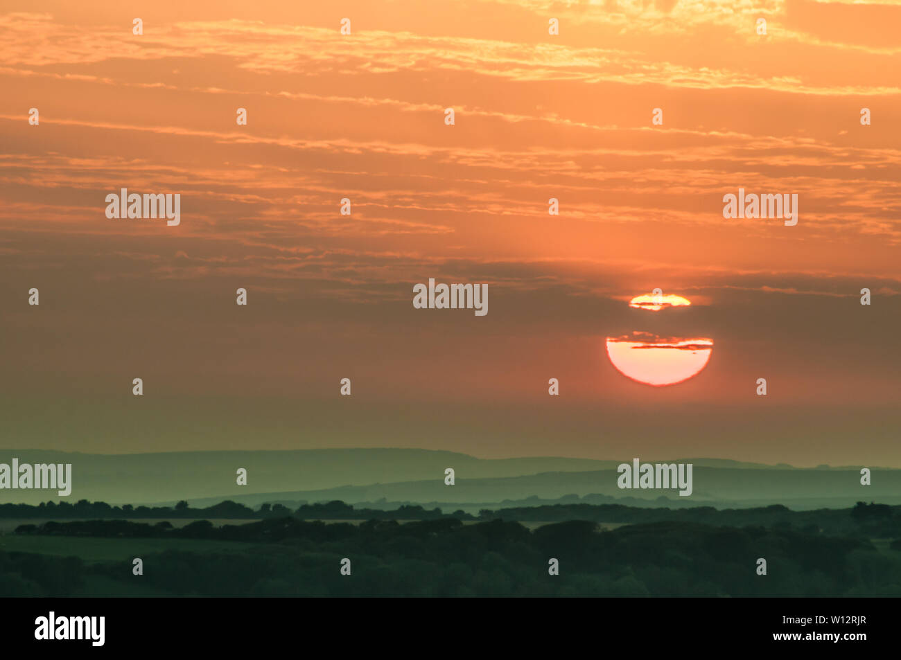 Beachy Head, Eastbourne, East Sussex, Regno Unito..26th Giugno 2019..Sun si affaccia sulla campagna mentre la nebbia marina si muove nell'addolcire la scena. . Foto Stock