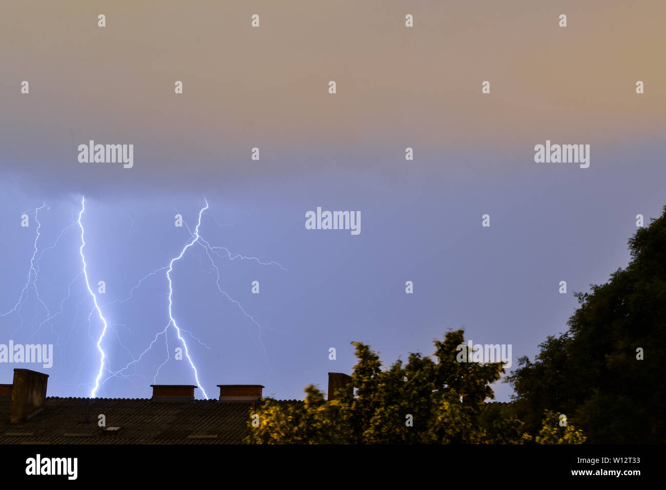 Il fulmine colpisce dietro edificio durante la tempesta in Croazia. Il fulmine colpisce dal grigio thunderclouds. Foto Stock