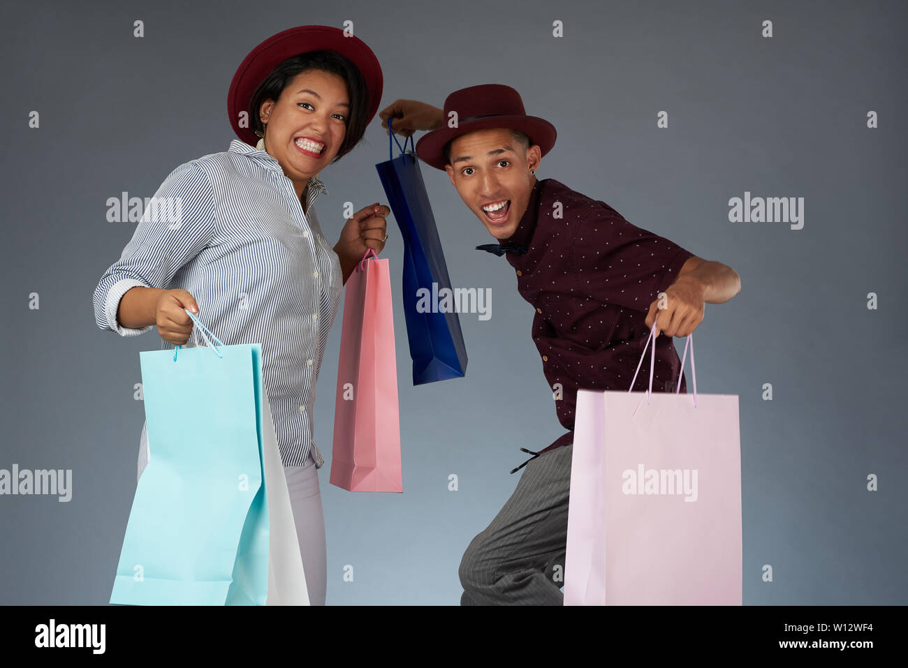 Happy jumping giovani latino-giovane con colorati borse per lo shopping Foto Stock