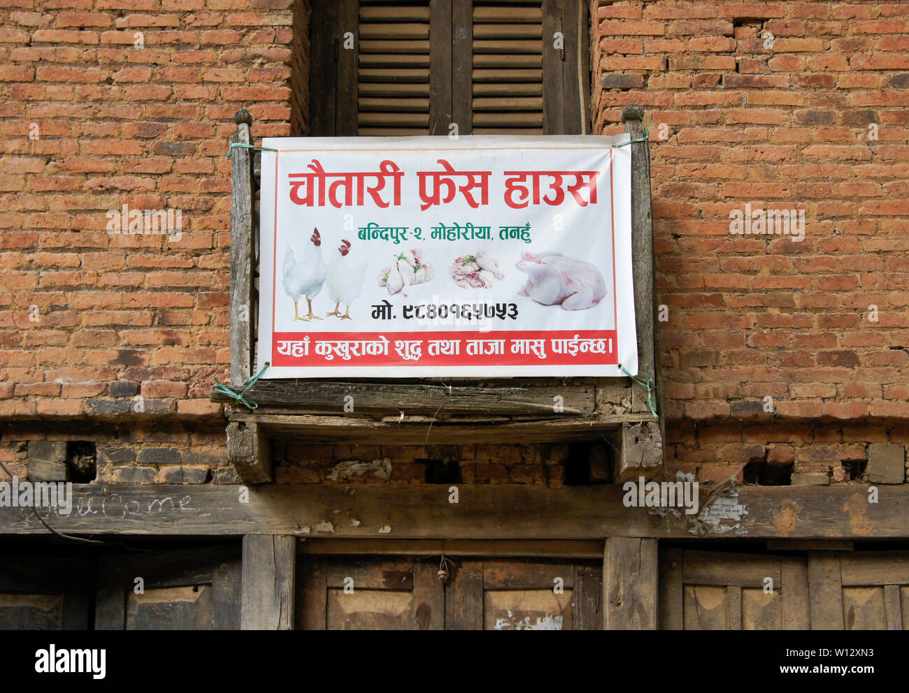 Segno pubblicità polli e il pollo in pezzi in vendita nel centro storico di Newari trading post città di Bandipur, Tanahan District, Nepal Foto Stock