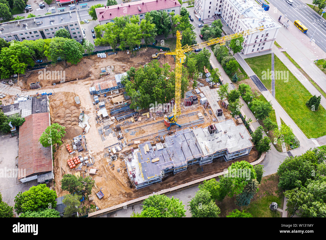 Costruzione di un nuovo edificio in centro città. giallo gru a torre e altre apparecchiature. drone immagine Foto Stock