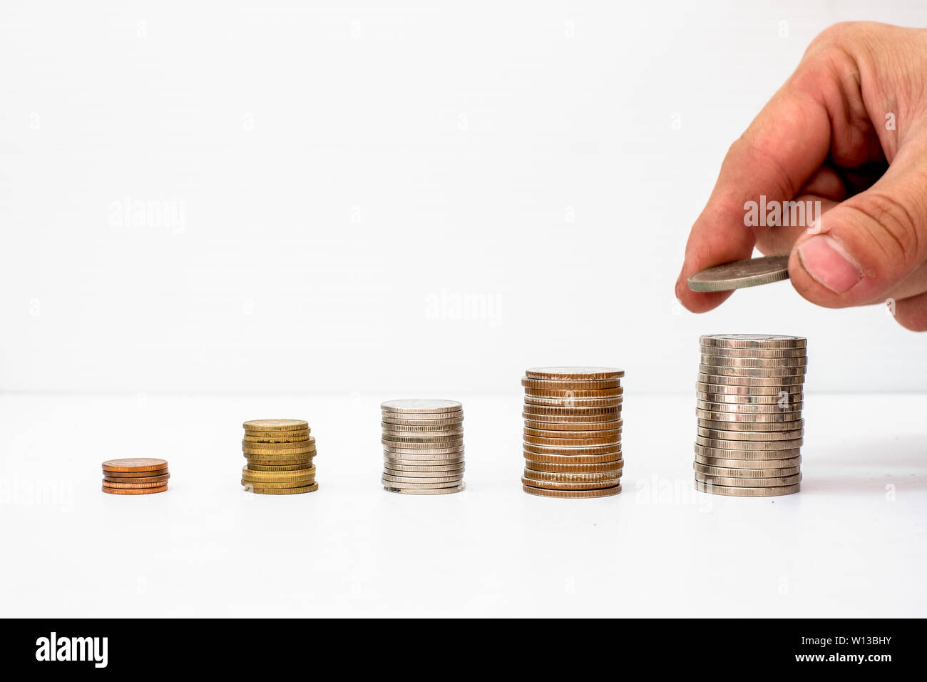 Raccolte a mano coin metti sul palo di fondi delle monete con valore alzarsi Foto Stock