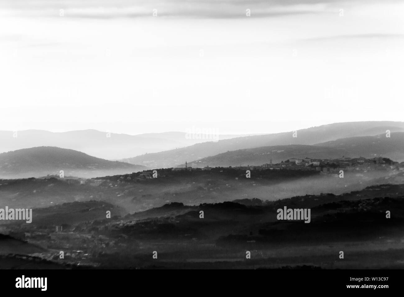 Una vista della città di Perugia (Umbria, Italia) nel mezzo delle colline e la nebbia Foto Stock