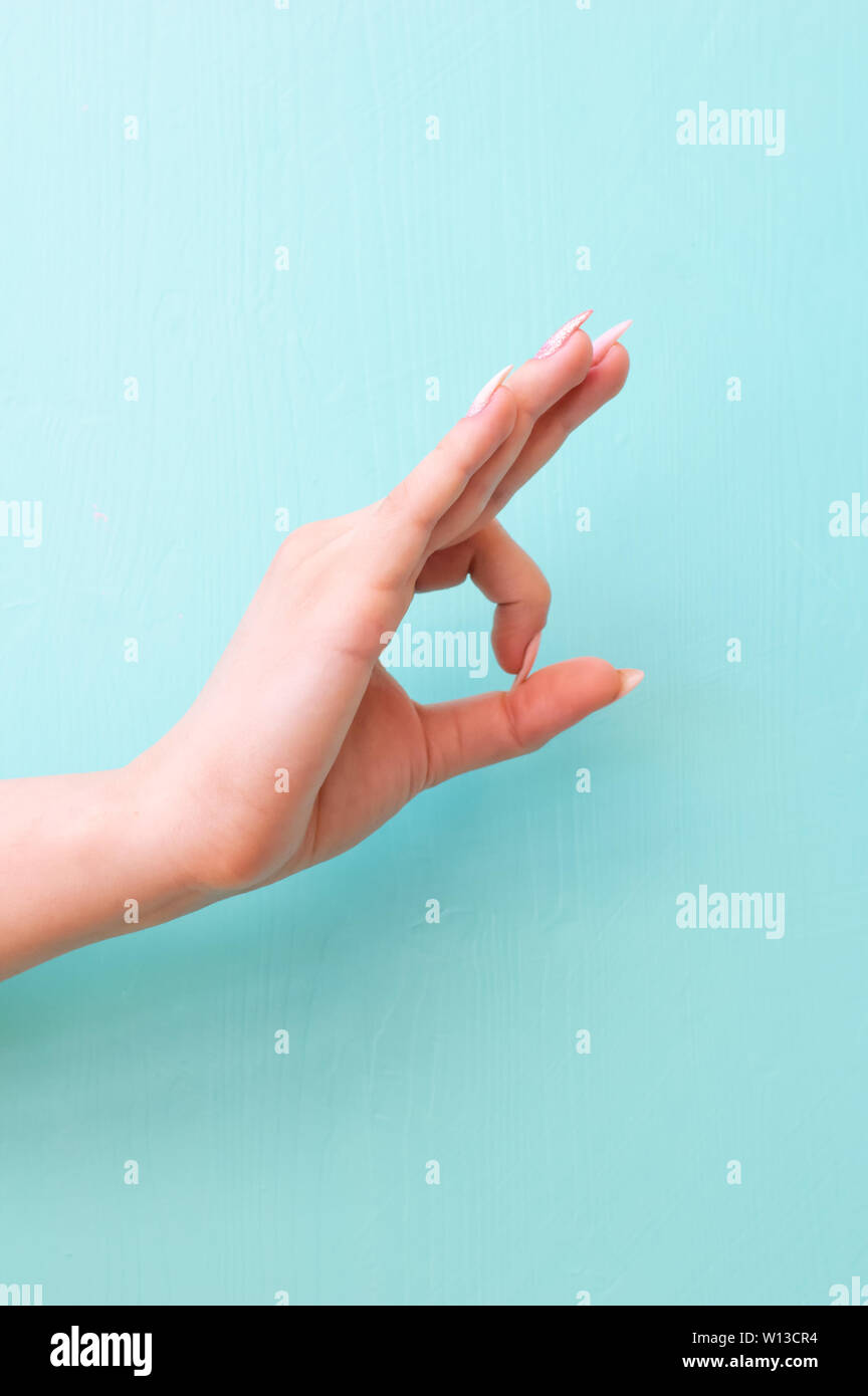 Mano femminile che mostra OK gesto sul colore di sfondo. Spazio per il testo Foto Stock
