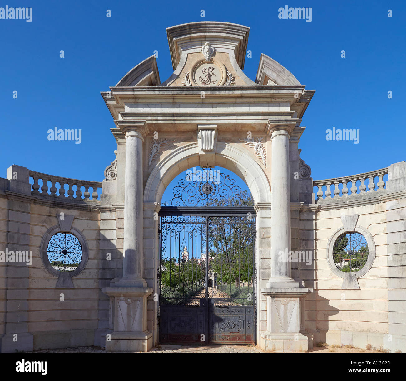 La Chiusa in ferro battuto e verniciato di colore nero del giardino e cancelli di ingresso ai giardini del palazzo di Estoi vicino al Faro in Portogallo in un pomeriggio di luglio. Foto Stock