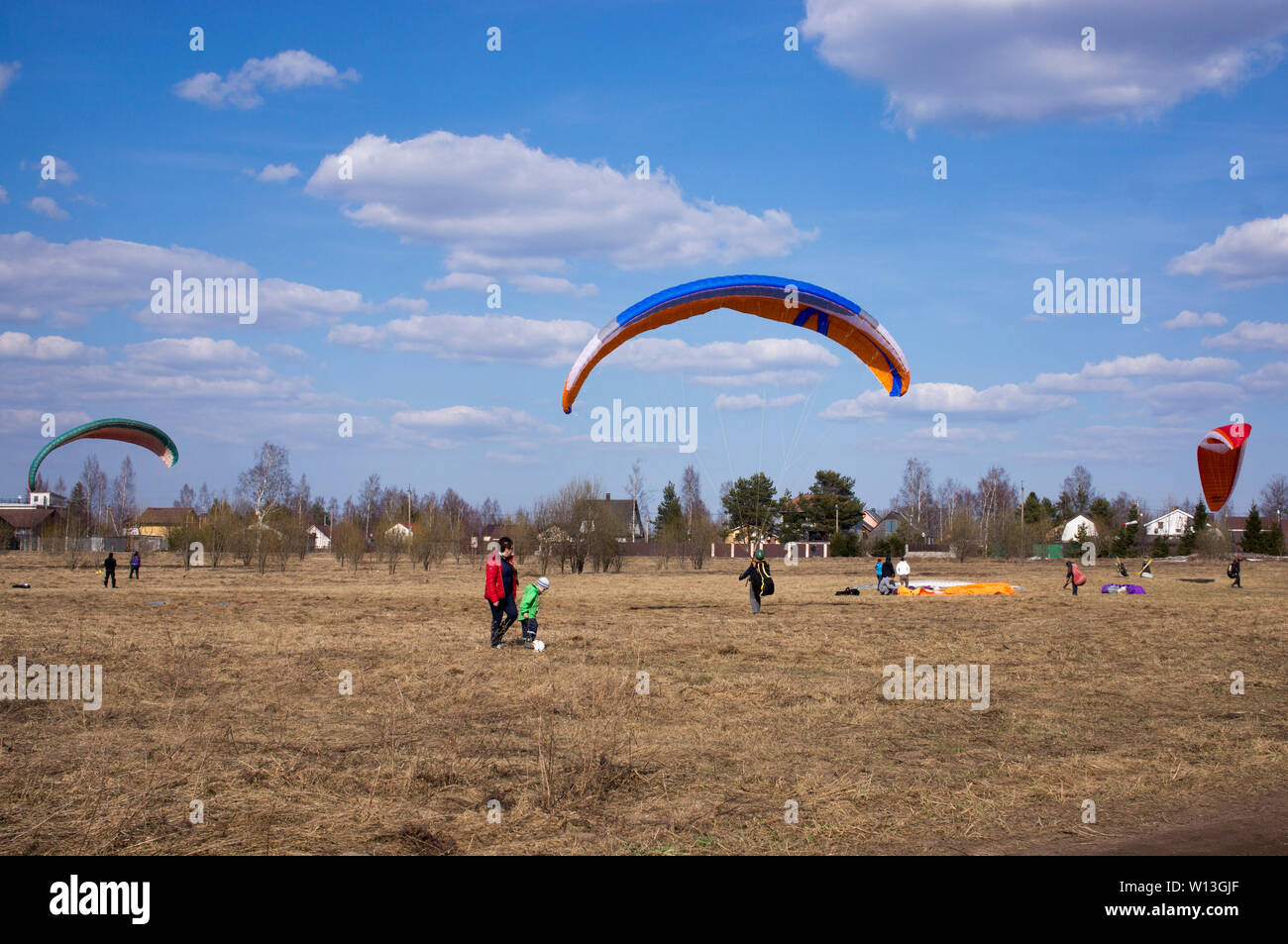 Regione di Leningrado Aprile 2019 parapendio vola contro lo sfondo di campi, terra. Vista da sopra. Parapendio Foto Stock
