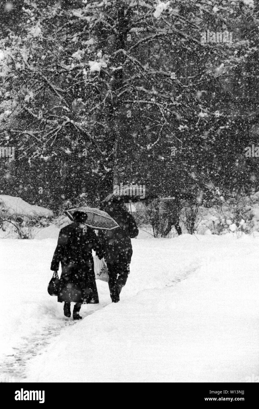 Il 26 marzo 1993 durante l'assedio di Sarajevo: in una pesante nevicata, una coppia di anziani a piedi attraverso la neve nel piccolo Parco adiacente alla Presidenza. Foto Stock