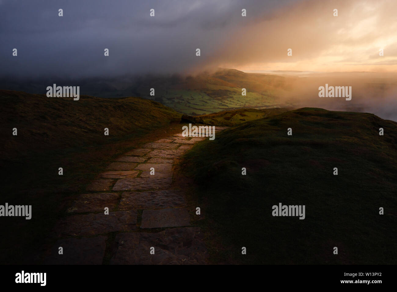 Epic presto l'alba sul Parco Nazionale di Peak District che mostra il solo percorso attraverso le lussureggianti colline Foto Stock