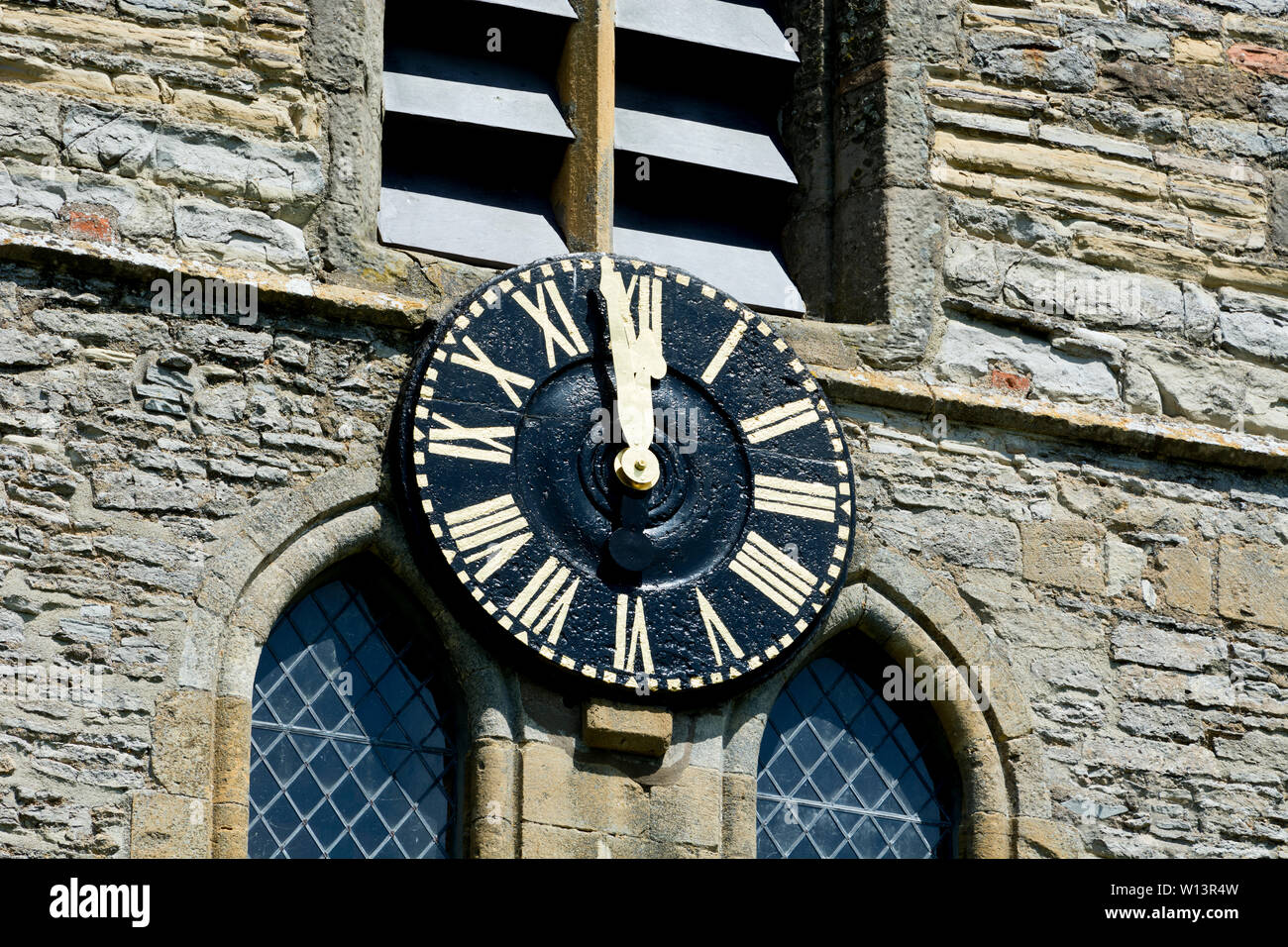 La Chiesa di San Pietro orologio solo prima di mezzogiorno, Welford on Avon, Warwickshire, Inghilterra, Regno Unito Foto Stock