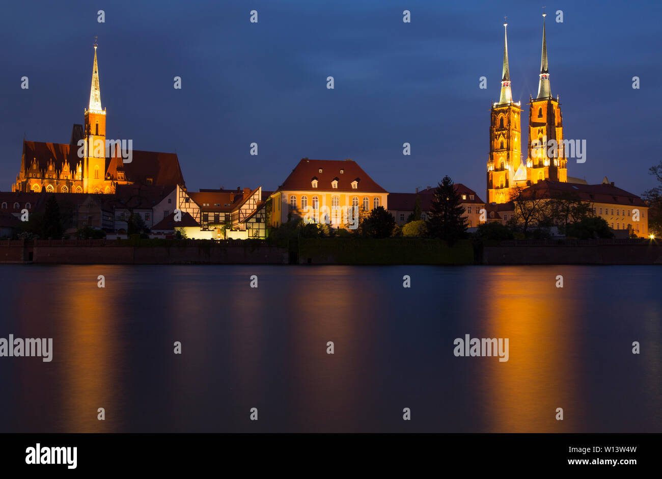La fotografia notturna. Vista sul fiume Odra: chiesa illuminata, Cattedrale ed edifici con riflessi nel fiume. Wroclaw, Polonia Foto Stock