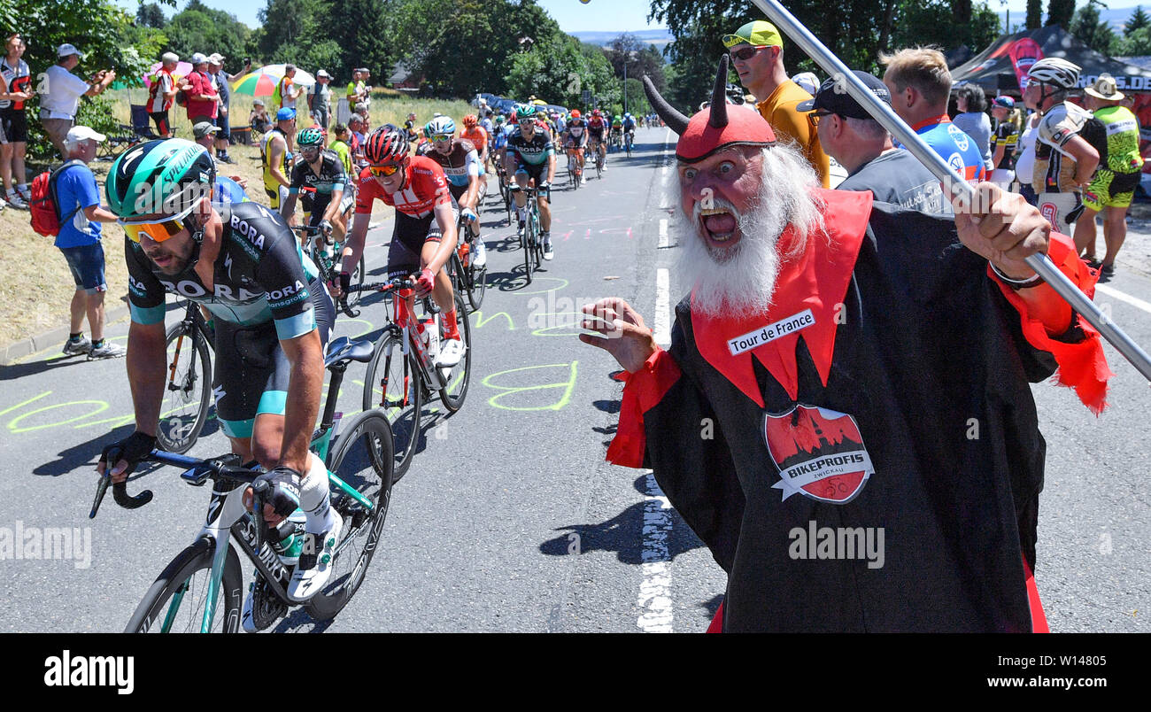 Hohenstein Ernstthal, Germania. Il 30 giugno, 2019. Escursioni in bicicletta, campionato tedesco, la gara su strada 180.60 km, uomini, al Sachsenring. Dieter 'Didi' Senft cheers sui driver di devil costumi presso la pista. Credito: Hendrik Schmidt/dpa-Zentralbild/dpa/Alamy Live News Foto Stock