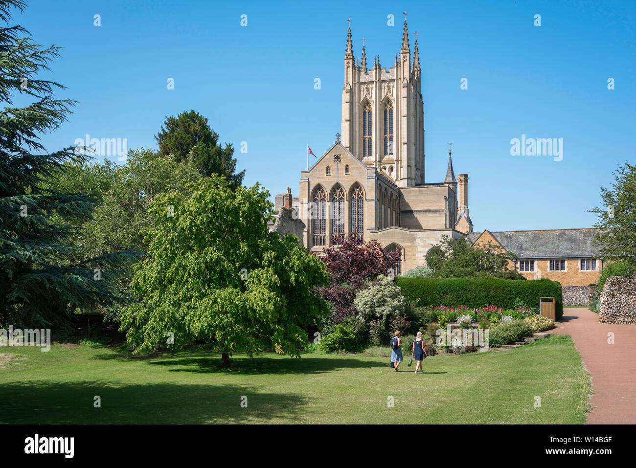 Abbey Gardens Bury St Edmunds, vista in estate di due donne in cammino verso St Edmundsbury Cathedral in Abbey Gardens, Bury St Edmunds, Suffolk, Regno Unito. Foto Stock