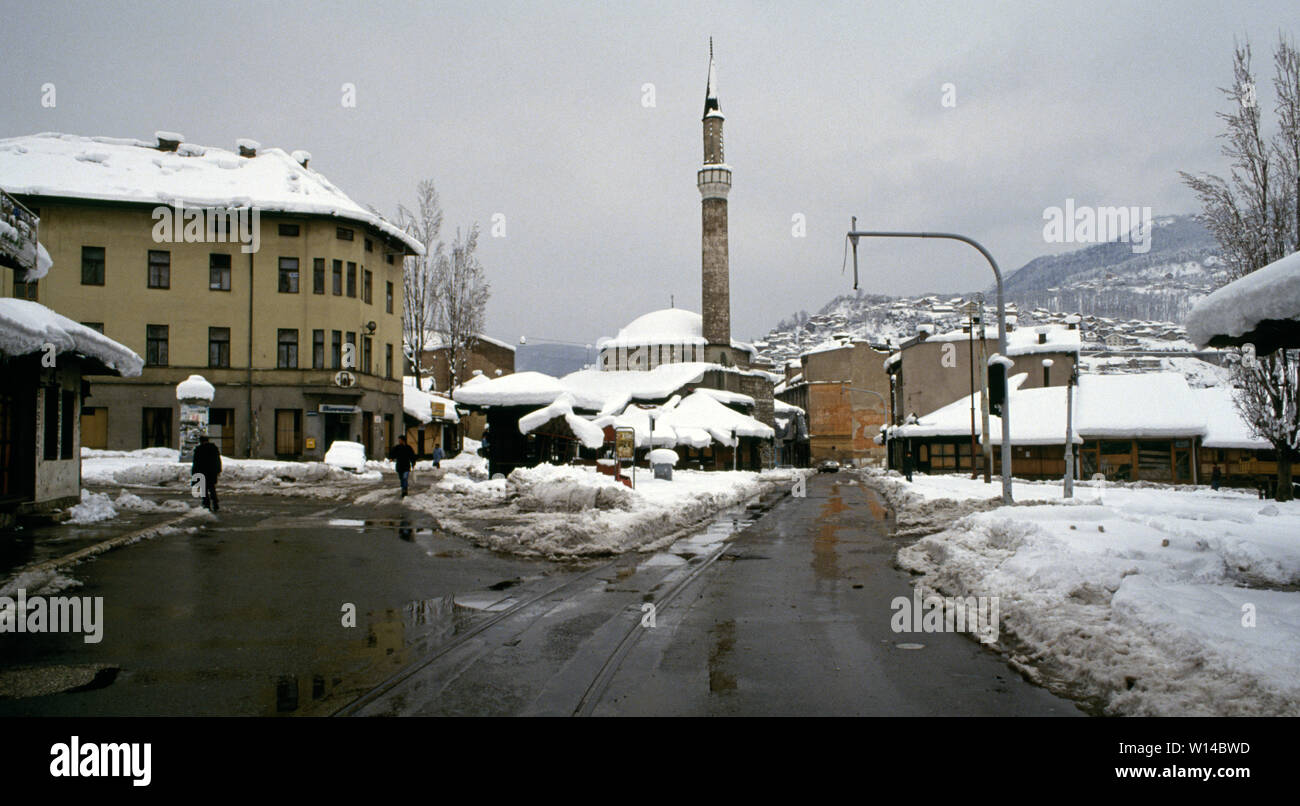 Il 28 marzo 1993 durante l'assedio di Sarajevo: la vista verso est lungo il Marsala Tita Street attraverso la piazza in Baščaršija, la zona della città vecchia. Il telaio centrale è la Baščaršija (Havadza Durak moschea). Foto Stock