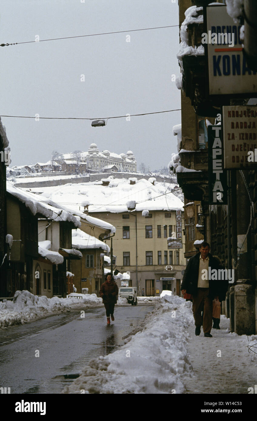 Il 28 marzo 1993 durante l'assedio di Sarajevo: la vista verso est lungo il Marsala Tita Street verso la piazza in Baščaršija. Il Jajce caserma militare stand alto su una roccia in background. Foto Stock