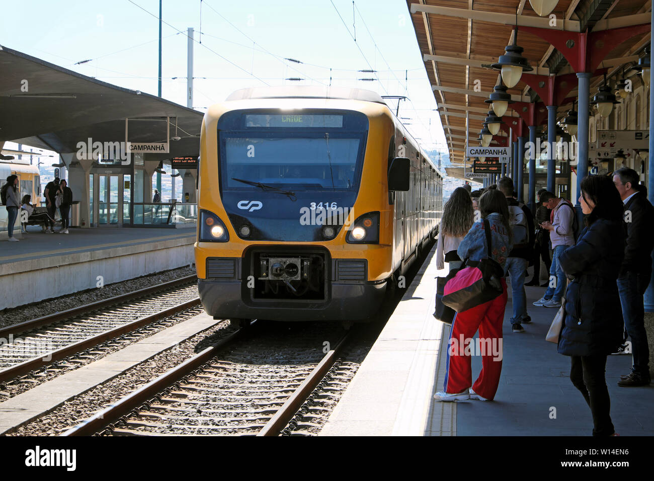 Persone passeggeri in attesa sulla piattaforma a bordo di un treno in avvicinamento a Campanhã stazione ferroviaria a Porto Oporto portogallo Europa KATHY DEWITT Foto Stock