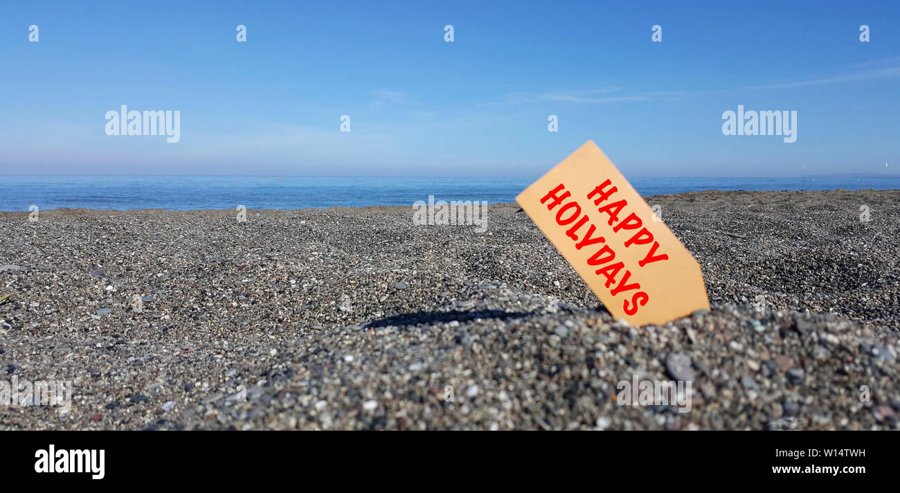 Tag sulla spiaggia con il testo delle vacanze felici Foto Stock