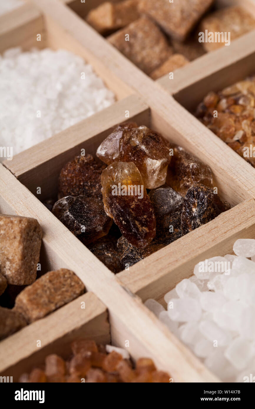 I vari tipi di zucchero in una scatola di legno. Raffinato bianco, marrone zucchero di canna raccolta Foto Stock