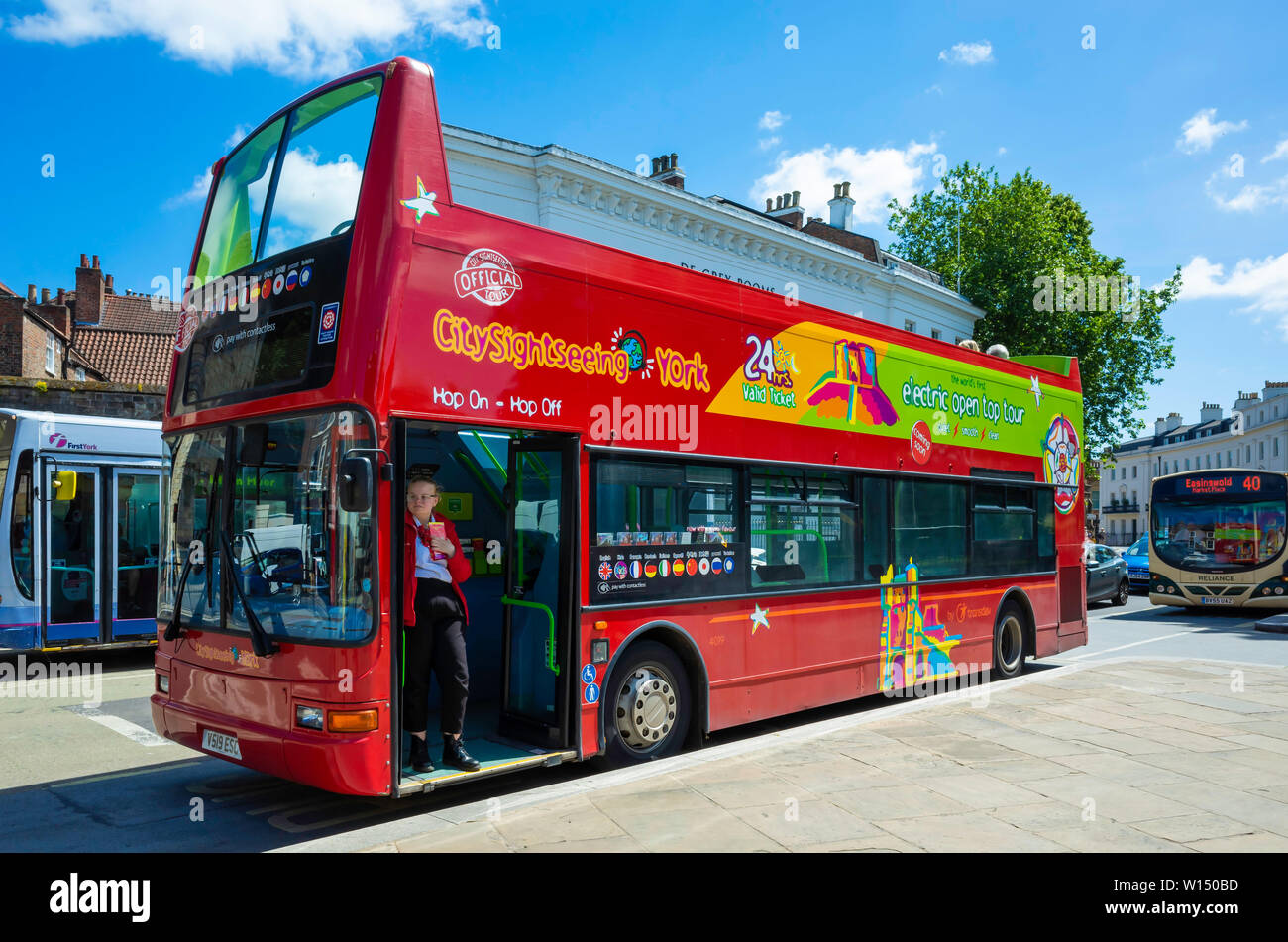 Un colore rosso brillante con sommità aperta hop-on hop-off double decker bus che porta i turisti in un tour intorno alla città di York Foto Stock