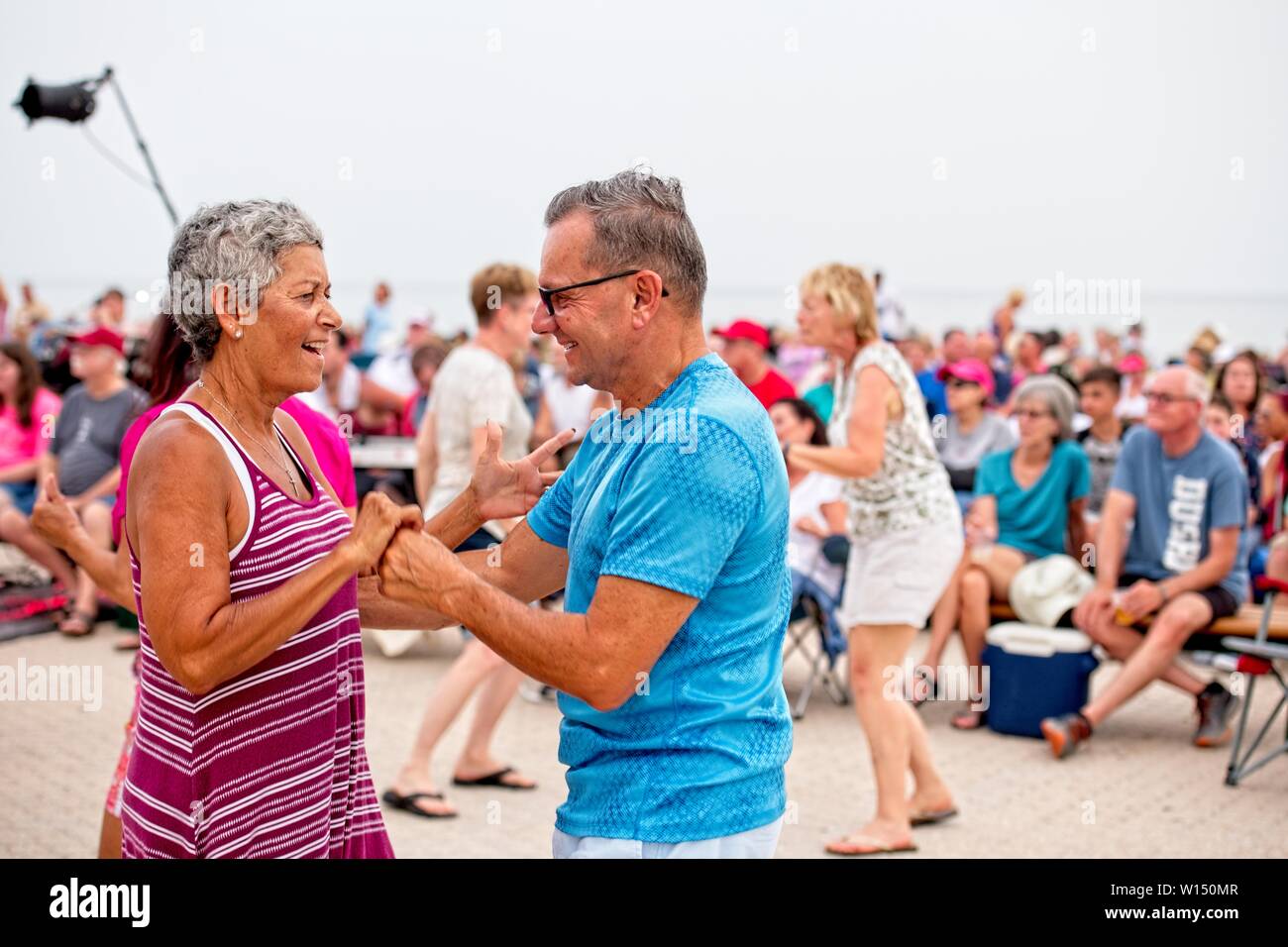 Una coppia di anziani ballano tra la folla in un festival sulla spiaggia di Pensacola, Florida Foto Stock