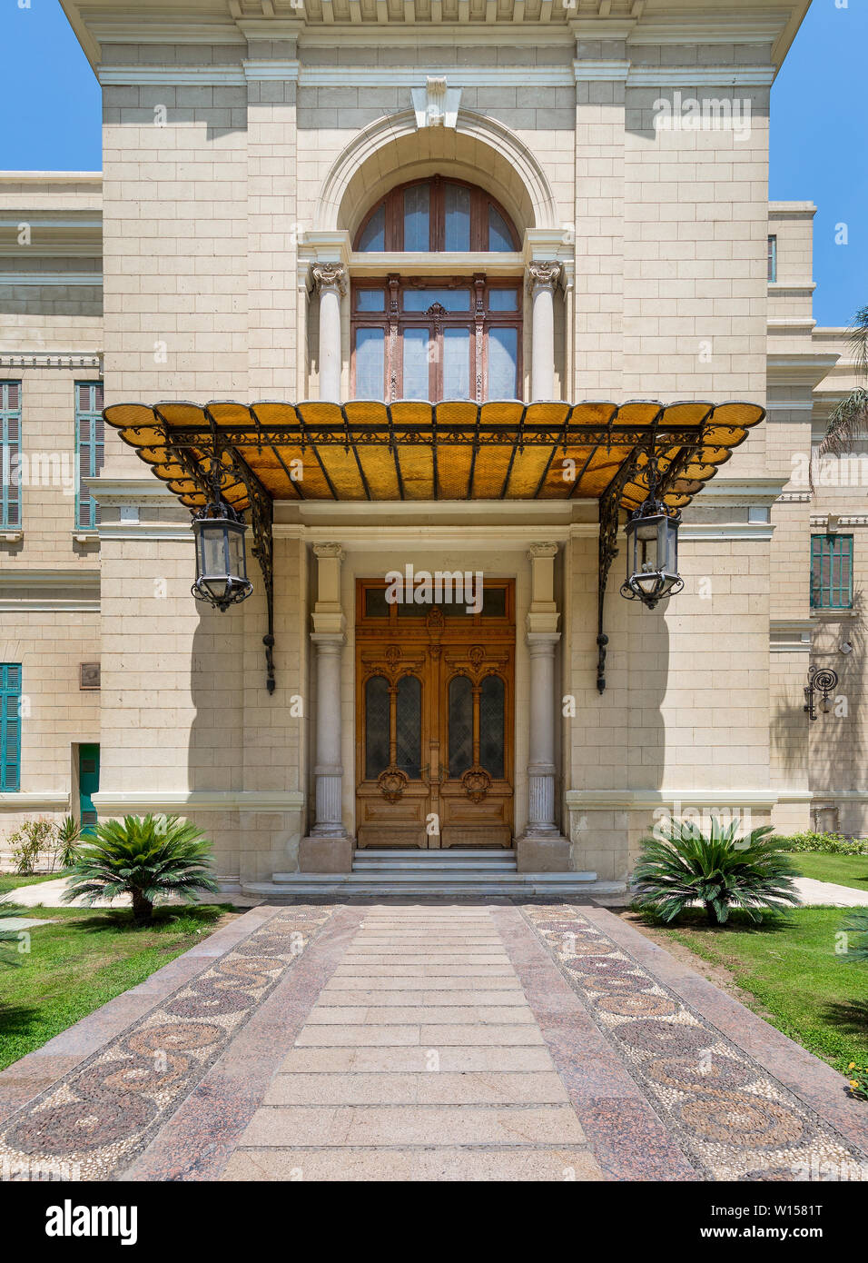 Decorate in legno antico porta e finestra in pietra di un muro in mattoni, ombrellone e due lanterne, la facciata di Palazzo Abdeen, Il Cairo, Egitto Foto Stock
