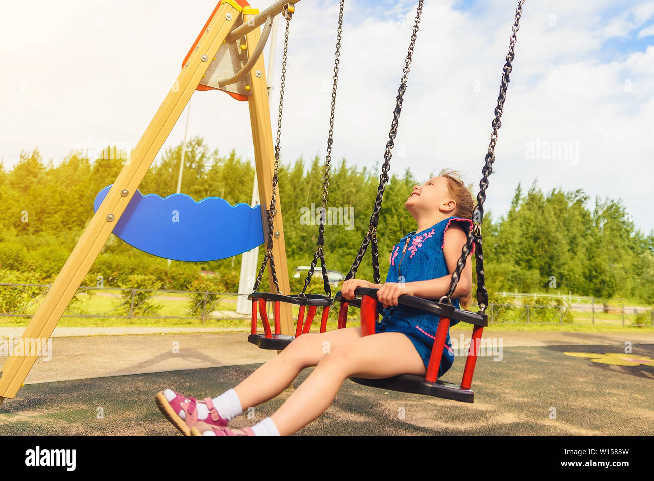 Bambino ragazza bionda divertirsi su uno swing Foto Stock