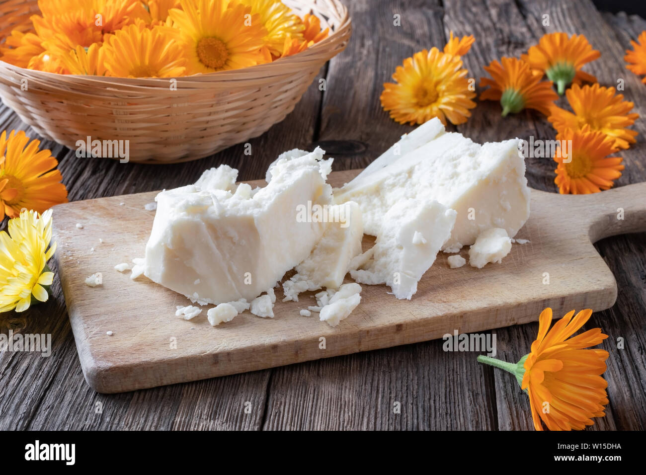 Ingredienti per parepare a casa la Pomata alla Calendula per digestione - grezzo grezzo di burro di karité e freschi fiori di tagete Foto Stock