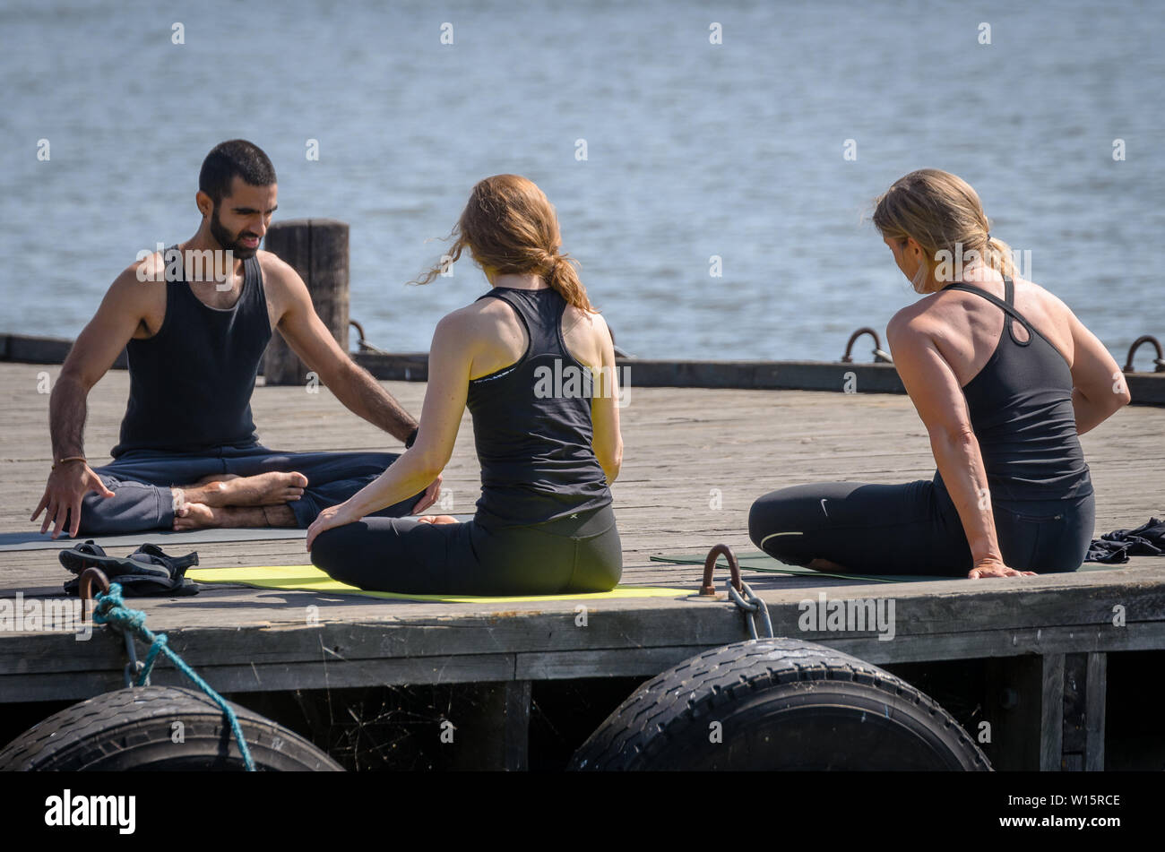 Esercizi yoga sul pontile sul battello a vapore Foto Stock