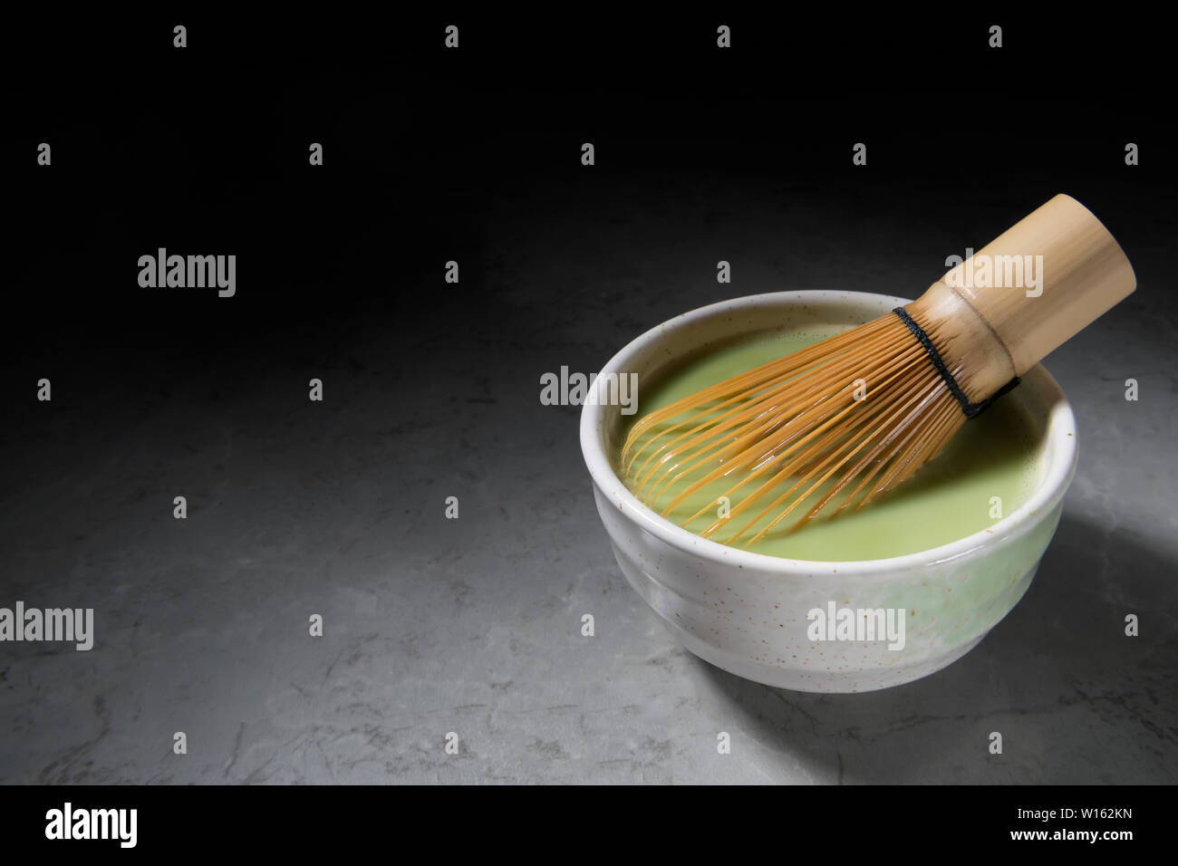 Organico del tè verde Matcha con bambù chasen in una ciotola in marmo grigio. Cerimonia del tè giapponese concetto, spazio copia, minimalismo Foto Stock