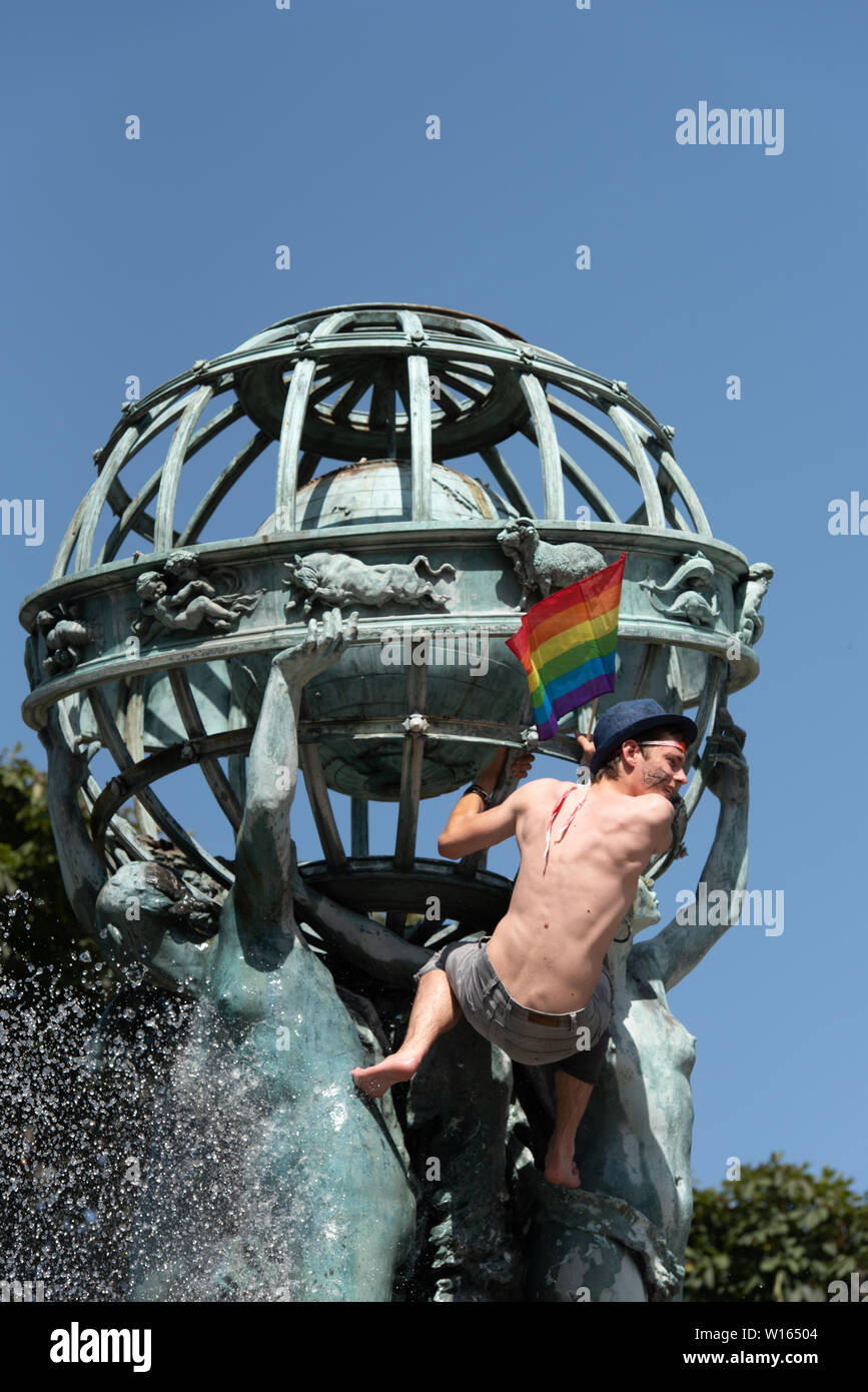 La gente si raffreddi nel Parc du Luxembourg fontana durante il Gay Pride 2019 che era su uno dei giorni più caldi dell'anno. Foto Stock