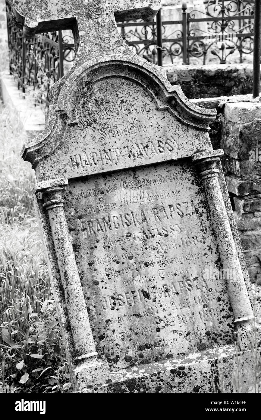 Ecka, Serbia - Giugno 2, 2019: Vecchia weathered crooked cristiane cattoliche tombestone al cimitero in bianco e nero Foto Stock
