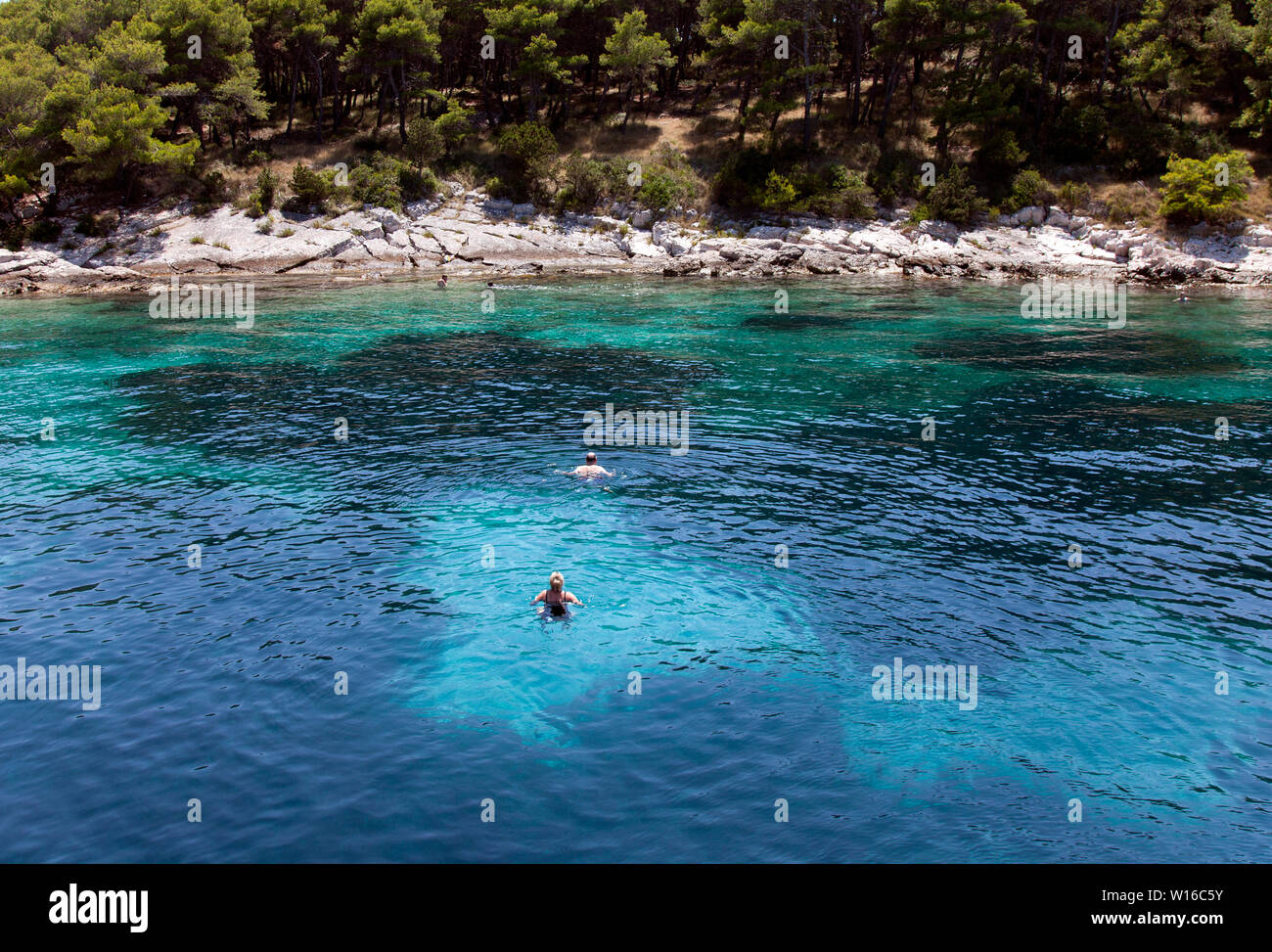 Le persone a nuotare in un mare Adriatico cove su un isola senza nome vicino a Hvar. Colore naturale; non è migliorata in Photoshop. Foto Stock