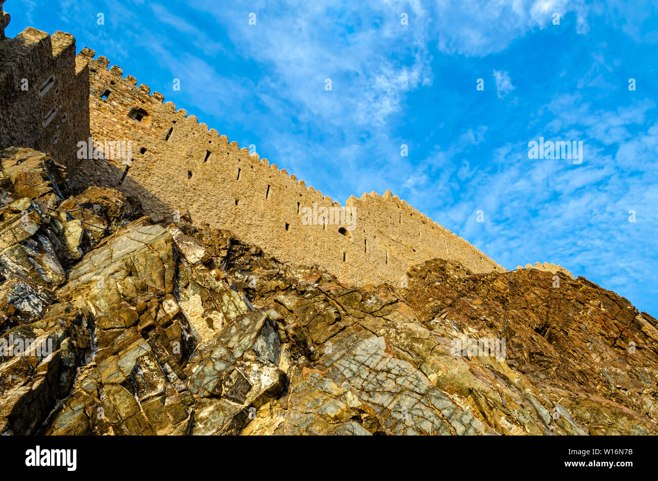 Muttrah fort parete su una collina rocciosa con cielo blu sullo sfondo. Inquadratura dal basso in Muscat,Oman. Foto Stock