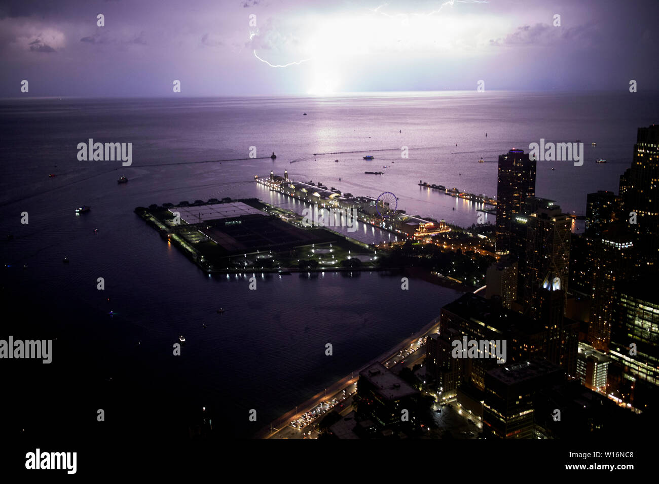 Vista da 360 chicago Observation Deck il John Hancock Building come scioperi di illuminazione sul lago michigan di notte oltre il Navy Pier Chicago IL USA Foto Stock