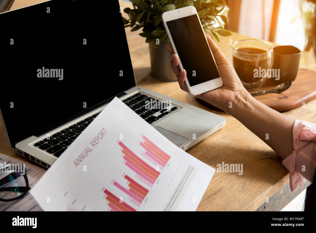 Vista superiore della giovane donna di lavoro utilizzando laptop e la lettura della relazione , grafici , grafici, documento al lavoro. Business donna lavora alla sua scrivania. Foto Stock