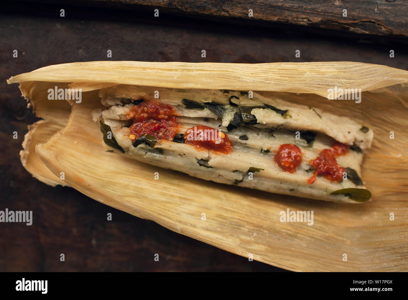 Tamales de chepil. In casa tamale con maíz (mais), chepil e alcune gocce di salsa di pomodoro, come se si trattasse di mangiare. San José del Pacífico, Oaxaca, Messico Foto Stock