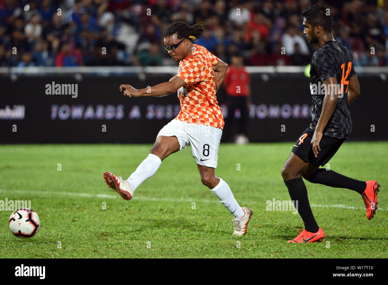 Johor Bahru, Malaysia. Il 30 giugno, 2019. Edgar Davids (L) di JDT Resto del mondo spara la sfera durante la JDT All-Stars cordiale carità match tra JDT TMJ JDT e resto del mondo a Johor Bahru, Malaysia, Giugno 30, 2019. Credito: Chong Voon Chung/Xinhua/Alamy Live News Foto Stock