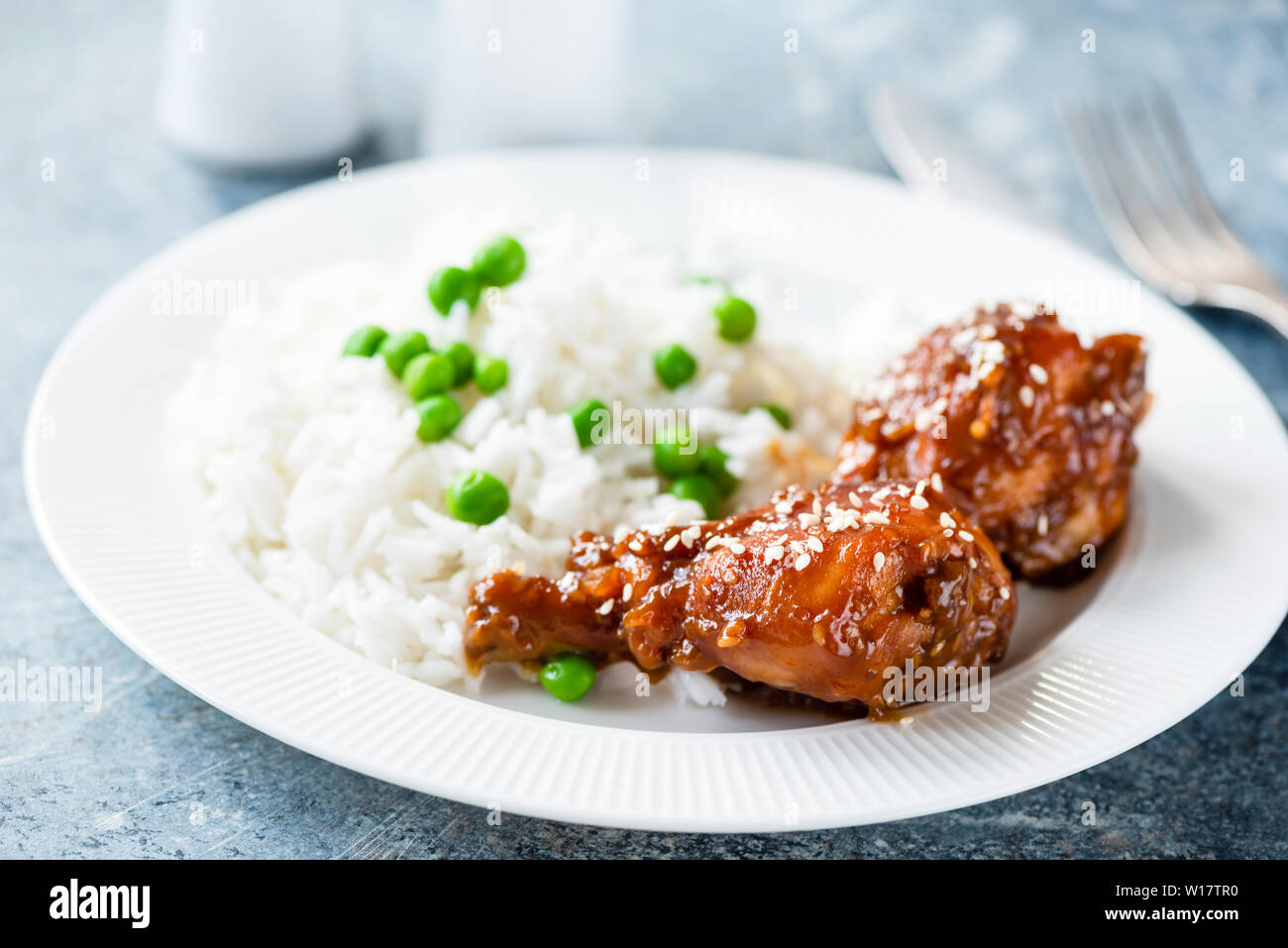 Cosce di pollo con riso e semi di sesamo sulla piastra bianca. Sana per la cena Foto Stock