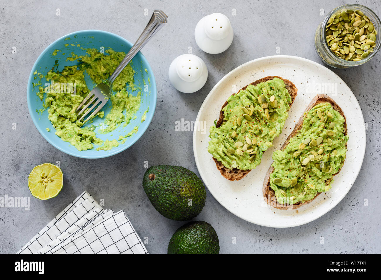 Avocado toast con semi e spezie. Pane di segale con purea di avocado. Tabella vista superiore, vegano sano cibo vegetariano Foto Stock