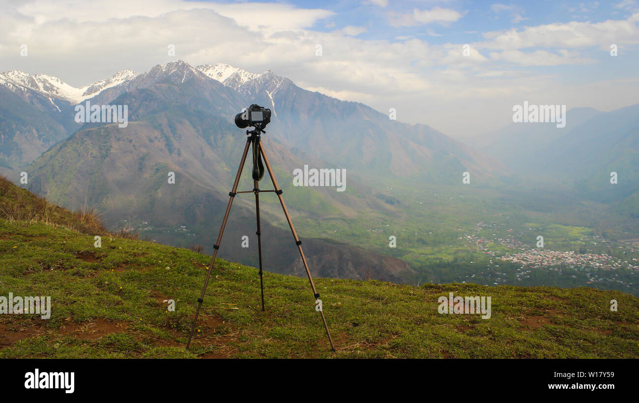 Srinagar, Jammu e Kashmir India- datata: Giugno 15, 2019: una Nikon D3200 fotocamera reflex digitale montato su un treppiede in alluminio con un ampio paesaggio di montagna in t Foto Stock