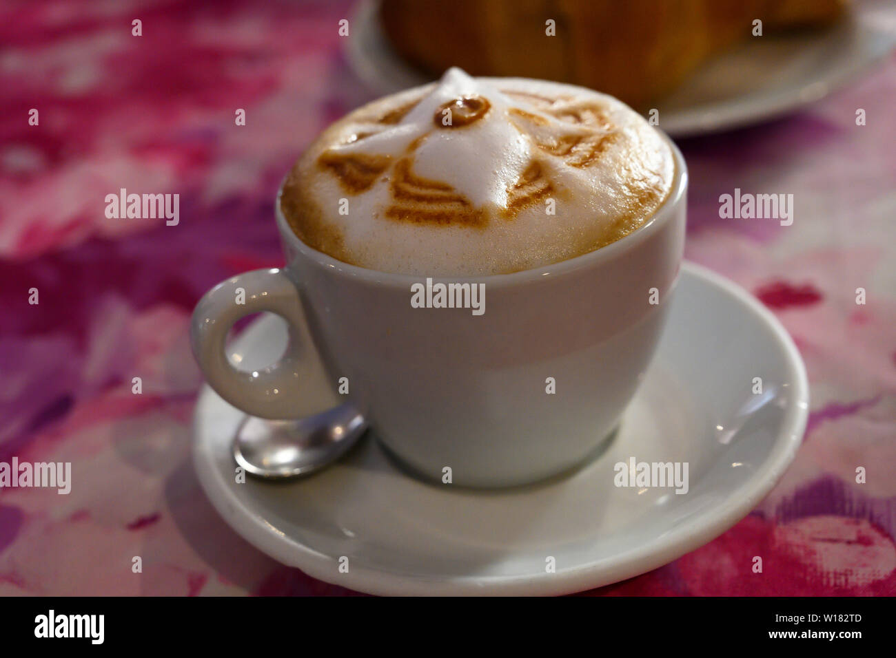 Tazza di cappuccino italiano isolato sulla tabella di rosa. Foto Stock