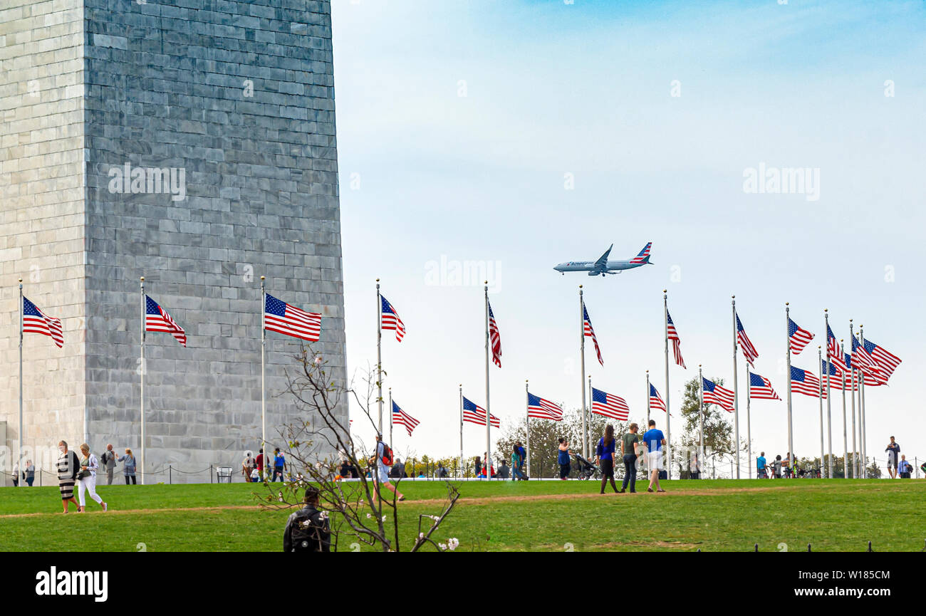 Washington D.C., USA, ottobre 2016; le persone che visitano il Monumento di Washington con un aereo commerciale lo sbarco in background Foto Stock